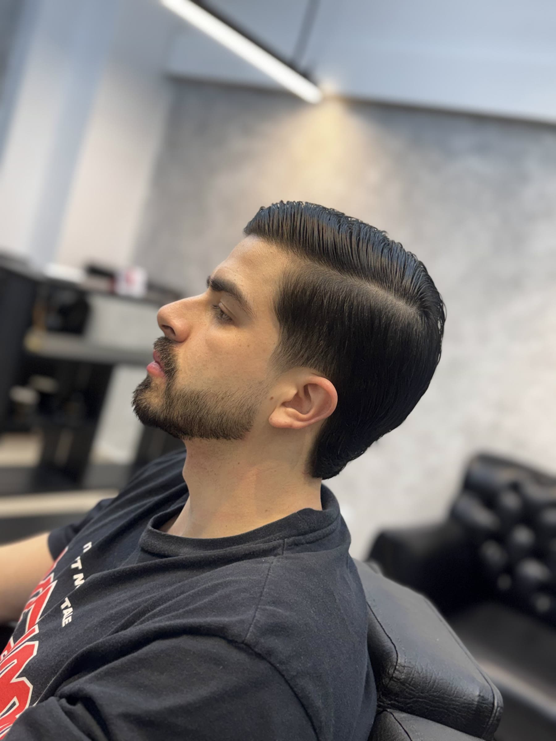 Perfil de un cliente con corte clásico y barba perfilada