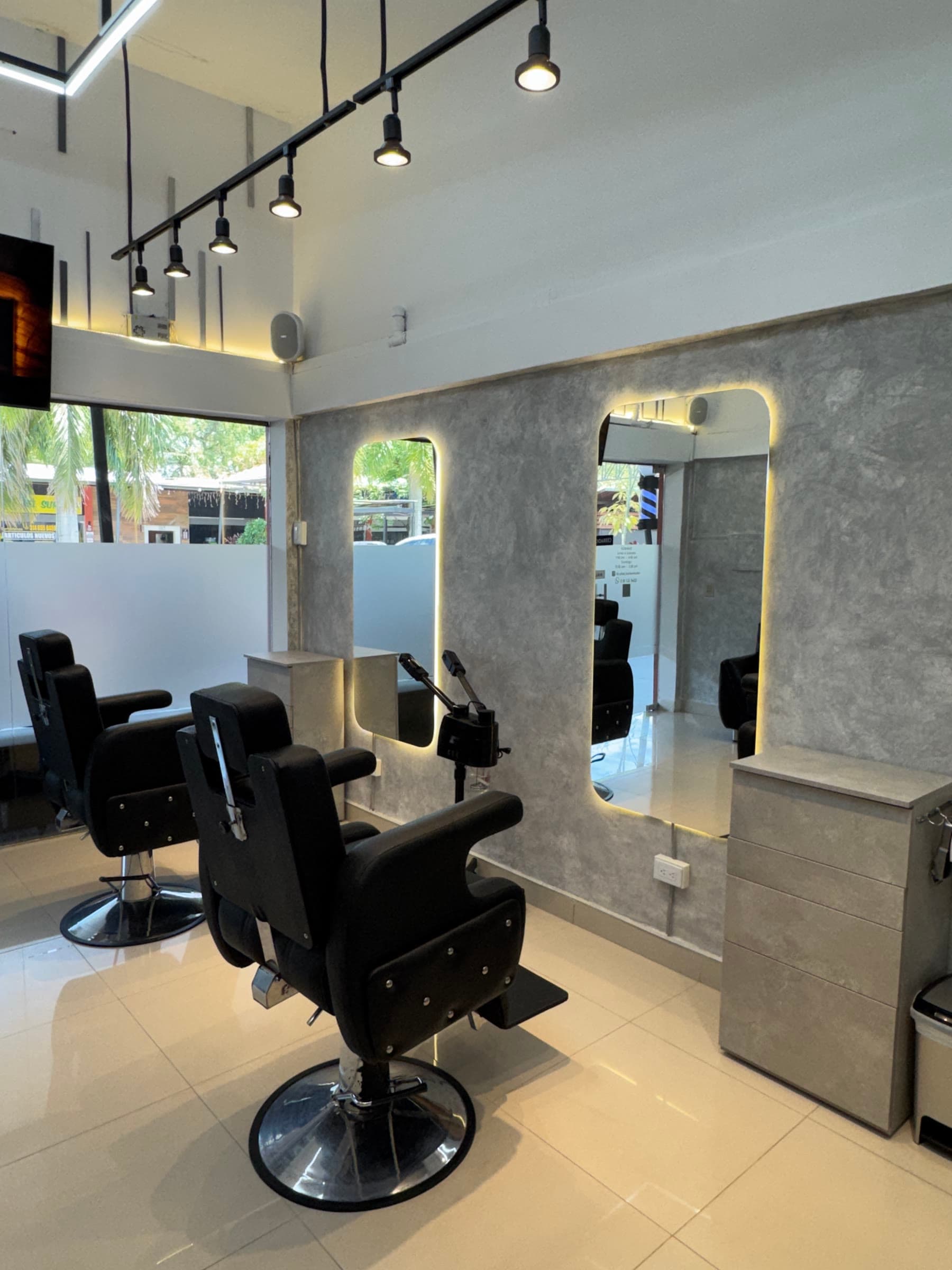 Estaciones de trabajo con espejos retroiluminados y sillones de barbero
